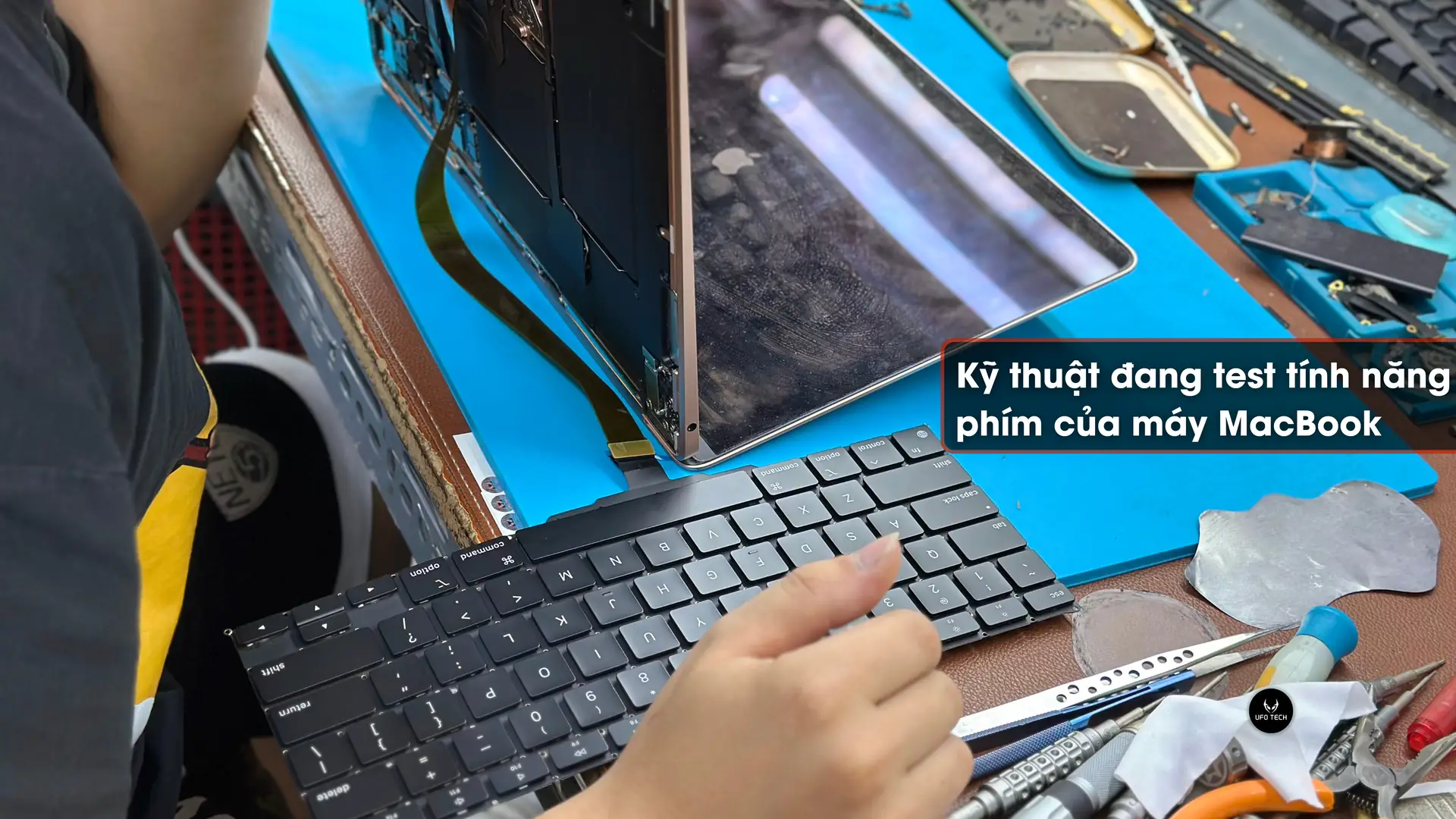 Kỹ thuật đang kết nối phím bên ngoài để kiểm tra tính năng của máy MacBook