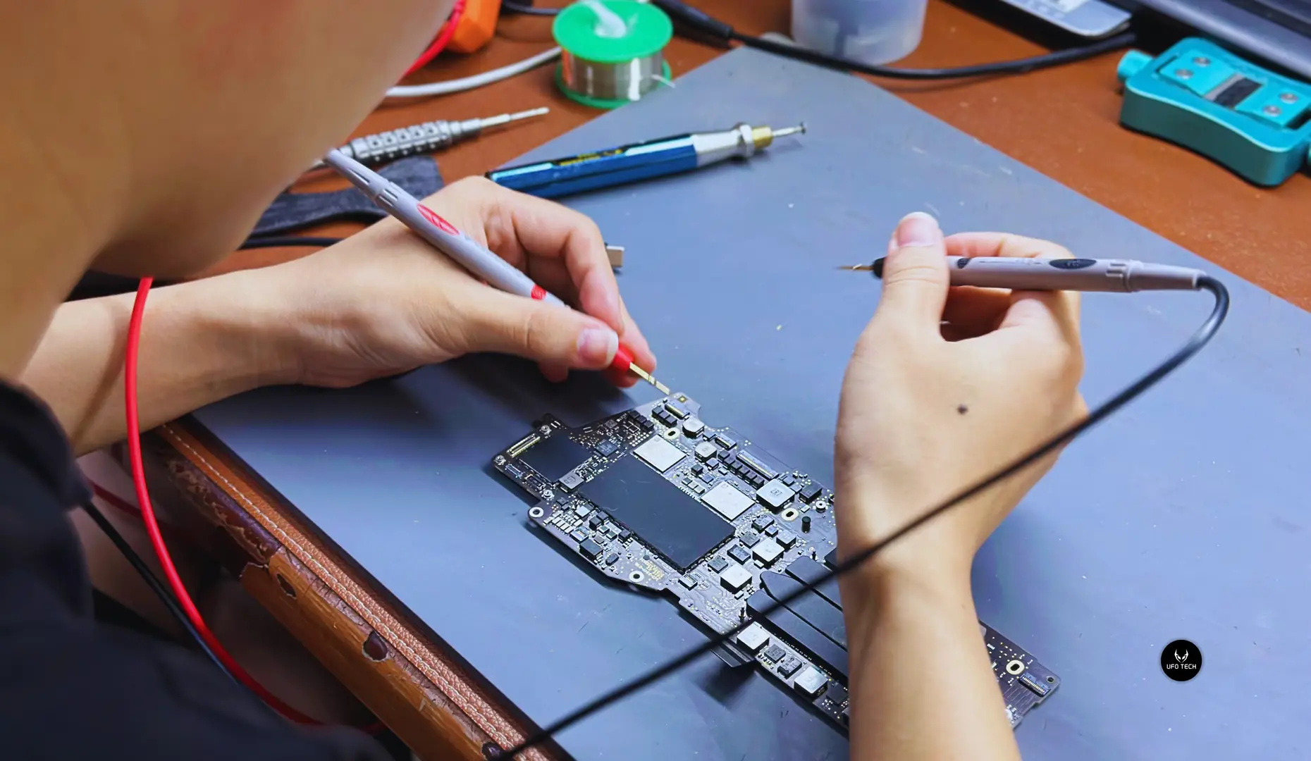 Kỹ thuật UFOTECH đang kiểm tra nguồn trên bo mạch MacBook