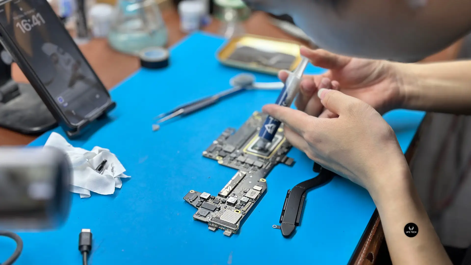 Kỹ thuật viên UFOTECH đang bảo dưỡng thay keo tản nhiệt cho MacBook