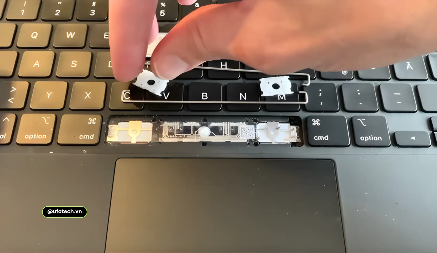 Ảnh chụp cận cảnh một bàn phím MacBook bị kẹt bụi hoặc kỹ thuật viên đang kiểm tra mâm phím.