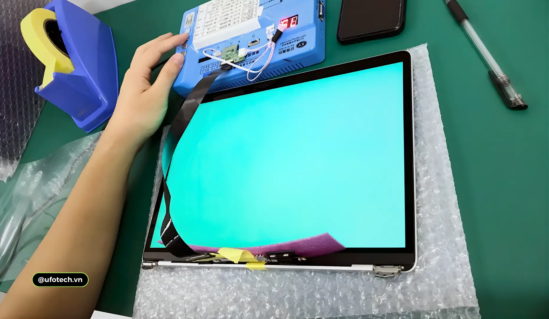 Kỹ thuật viên UFOTECH đang kiểm tra kỹ lưỡng tình trạng màn hình MacBook trước khi tư vấn thay thế.